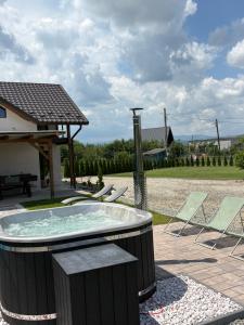 a hot tub with two chairs and a picnic table at Cabana Carpatin in Ocna-Mureşului