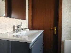 a bathroom with a white sink and a wooden door at Casa Vacanze Le Cascate in Le Marmore +68 photos