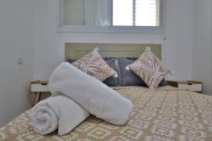 a bed with a pile of white towels on it at אירוח סמוך לים התיכון יש מקלט בבניין in Haifa