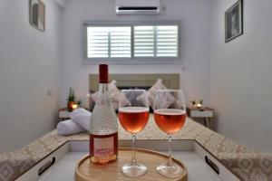 a bottle of wine and two glasses on a counter at אירוח סמוך לים התיכון יש מקלט בבניין in Haifa