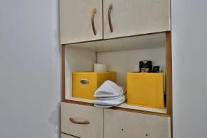 a cabinet with yellow boxes and towels on it at אירוח סמוך לים התיכון יש מקלט בבניין in Haifa +7 photos