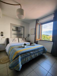a bedroom with a bed with a large window at Casa Vacanze Le Cascate in Le Marmore