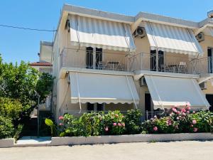 a building with balconies and flowers in front of it at Riverside Rooms Ammoudia in Ammoudia