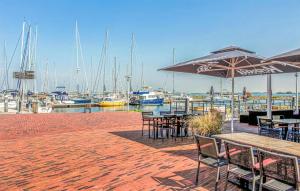 a patio with tables and chairs with boats in a marina at Zilt en Zen Zeeland in Bruinisse