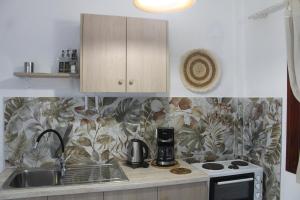 a kitchen with a sink and a stove top oven at Anastazia's Seaside Apartments in Roda