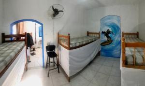a room with two bunk beds and a painting of a surfer at Bouganvile Hostel Ilha Grande in Abraão +10 photos