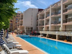 a hotel with a swimming pool next to a building at Tropics Hotel by Aleksis in Sveti Vlas