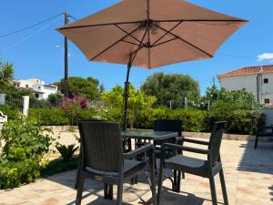 a table and chairs with an umbrella on a patio at Calliopi's studio in Plytra
