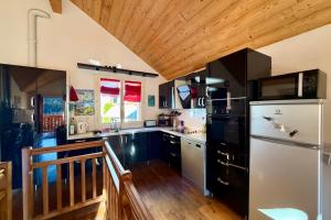 a kitchen with a white refrigerator and a wooden ceiling at Charming and bright cottage in Briançon in Briançon