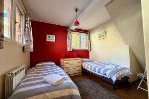 two beds in a room with red walls at Charming and bright cottage in Briançon in Briançon +17 photos