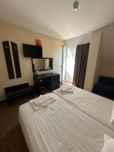 a hotel room with a large bed and a television at Tropics Hotel by Aleksis in Sveti Vlas