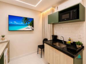a bathroom with a sink and a tv on the wall at Fortaleza Sul Prime By Holiday Stays in Fortaleza