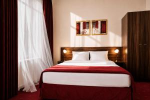a bedroom with a bed with a red blanket at Hotel Centrum Sosnowiec in Sosnowiec