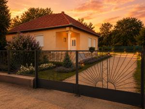a gate in front of a house at sunset at Levendula Vendégház in Verpelét +16 photos