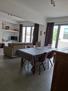 a living room with a table and a couch at De Reünie - airconditioned duplex appartement & fietsgarage in Langemark