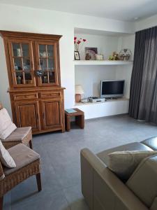 a living room with a couch and a tv at De Reünie - airconditioned duplex appartement & fietsgarage in Langemark