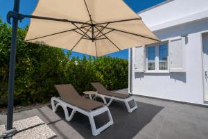 a pair of chairs and an umbrella on a patio at Lu Chiapparu B&B in Nardò