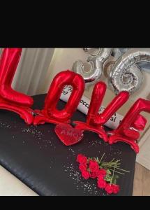 a heart shaped cake with red frosting and red roses at Atena B&B APARTMENTS Platino in San Silvestro