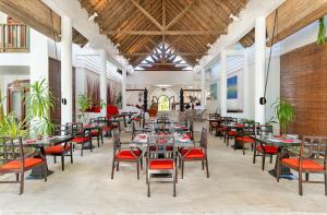 a restaurant with tables and chairs in a building at Village du Pecheur in Baie Sainte Anne