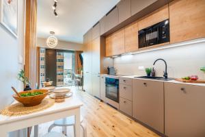 a kitchen with wooden cabinets and a counter top at Global Apartments Katowice in Katowice