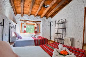 a bedroom with two beds and a window at Cuevas El Moral in Castilléjar +48 photos