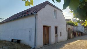 a white building with a wooden door on a street at Apartmán 7J in Hnanice