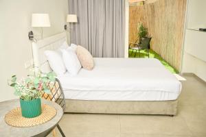 a bedroom with a bed and a table with a chair at H7 TLV in Tel Aviv