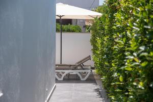 a bench sitting on a patio next to a hedge at Lu Chiapparu B&B in Nardò +54 photos
