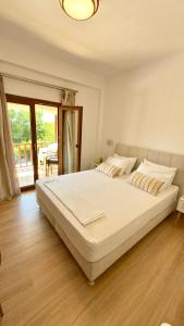 a large white bed in a bedroom with wooden floors at Edem Haven Luxury Apartment in Skala Fourkas +25 photos