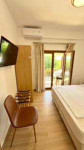 a bedroom with a bed and a chair and a balcony at Edem Haven Luxury Apartment in Skala Fourkas