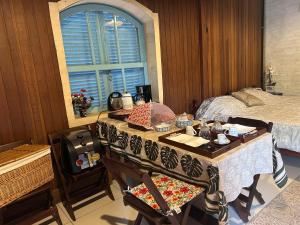 a bedroom with a table and a bed and a window at Chalé Manancial in Socorro