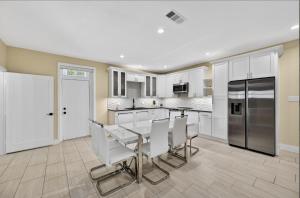 a kitchen with white cabinets and a table and chairs at Korovosoto Lodge in Dallas +24 photos