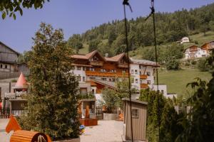 a group of buildings in a town with a tree at Kinderhotel Laderhof in Ladis