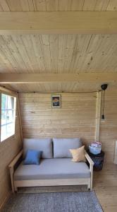 a couch in a room with a wooden ceiling at Kempings Roja in Roja