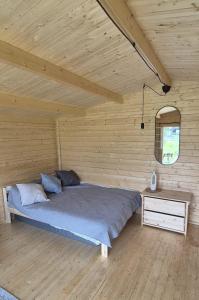 a bedroom with a bed and a wooden wall at Kempings Roja in Roja +33 photos