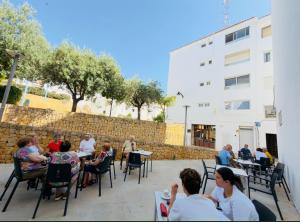 a group of people sitting at tables in a patio at Alteagroup Joy in Altea