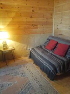 a bedroom with a bed and a table with a lamp at Gîte l'appel de la Forêt in Betplan