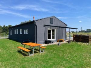 a small gray house with a picnic table and benches at Ferienwohnung Bahnblick - Stilvoll in bester Lage - als Wohnung oder Haus in Olbersdorf