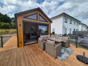 a patio with a table and chairs on a deck at Eifelchalet Mendig in Mendig