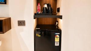 a black refrigerator with a shelf on top of it at Hotel Jewels at Rajpur Road in Dehradun