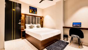 a hotel room with a bed and a chair at Hotel Jewels at Rajpur Road in Dehradun