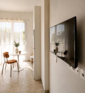 a living room with a flat screen tv on a wall at Noéma Mani Boutique Residences in Gythio