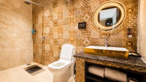 a bathroom with a toilet and a sink and a mirror at Hotel Jewels at Rajpur Road in Dehradun +31 photos