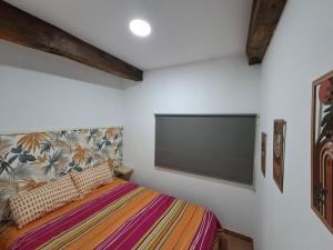 a bedroom with a large flat screen tv on the wall at Apartamento en Casa Celia in Orol