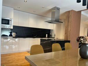 a kitchen with white cabinets and a glass table at Villa Vildana in Sarajevo