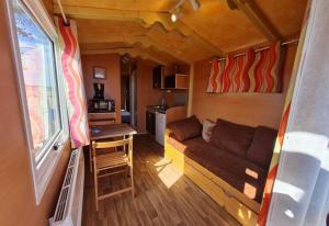 a living room and kitchen in a tiny house at Roulotte tout confort au milieu des animaux in Burthecourt-aux-Chênes