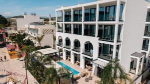an overhead view of a white building with palm trees at Colosseum Hotel in Ksamil