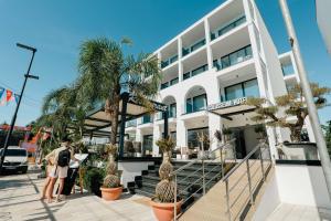 a man and a woman standing outside of a building at Colosseum Hotel in Ksamil