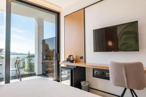 a bedroom with a bed and a tv and a window at Colosseum Hotel in Ksamil