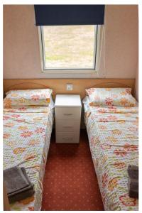 two twin beds in a small room with a window at La Belle Vue in Durmignat